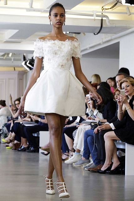 In this April 18, 2015 photo, a model wears a creation from the Oscar de la Renta Bridal Spring 2016 collection in New York. Peter Copping, hired last October as artistic director of the luxury label, retained much of the classic de la Renta glamour but added a few more modern-looking silhouettes, some new takes on fabric work, and some silvery sequins.