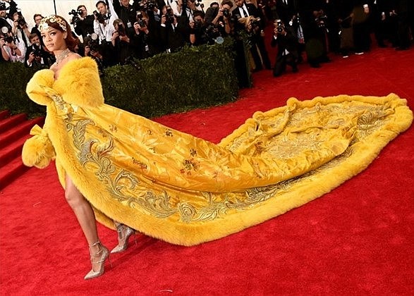 Rihanna  arrives at the Met Gala in a stunning yellow coat obviously designed for royalty.