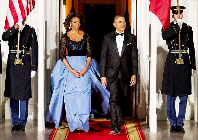 This Feb. 11, 2014 file photo shows President Barack Obama and first lady Michelle Obama arrive at the North Portico of the White House in Washington to greet French President François Hollande, who is arriving for a State Dinner. 