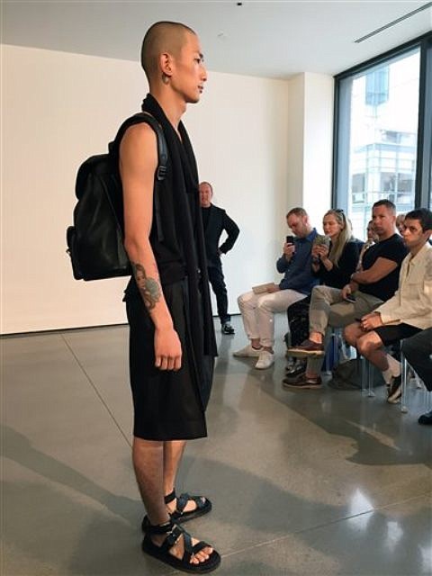 Fashion from Michael Kors is modeled on Wednesday, July 15, 2015, in New York. Kors, standing right, presented his men’s collection in an intimate setting personally presenting each of his 27 looks to a small crowd of fashion media and buyers.