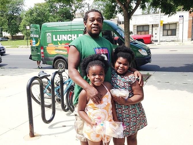 Marilyn Ogaldez, 8, and her sister, Phillicia, 7, regularly get free meals from the Greater Chicago Food Depository's "Lunch Bus." The two girls get lunch at the bus after their father, Phillip Ogaldez, brings them to West Englewood Library, 1745 West 63rd St., Chicago.