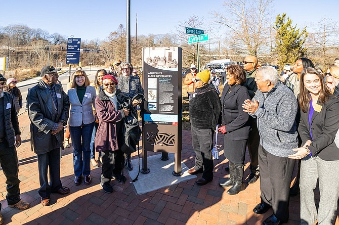From L to R: Matthew Bacoate, Jr., Catherine Mitchell, Vice Mayor Sandra Kilgore, Buncombe County Commissioner Al Whitesides and others in front of an Asheville Black Cultural Heritage Trail panel. Explore Asheville Convention & Visitors Bureau.