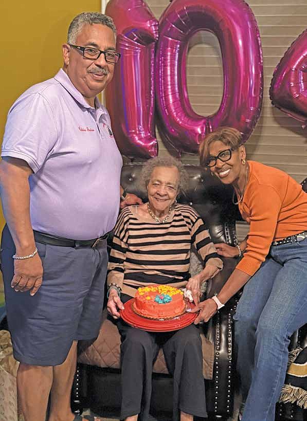 Mother McDuffie poses for a picture holding a cake in celebration of her 104th Birthday. McDuffie is pictured with Rich Township Supervisor Calvin Jordan and Commissioner Lori Jordan. PHOTO PROVIDED BY STH MEDIA LLC.