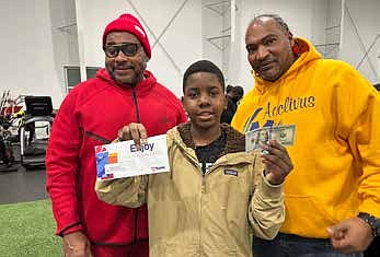 Acclivus leaders Bamani Obadele (l) and Tomas Ortiz (r) with one
of hundreds of youth who received toys, electronics or cash at the
organization’s recent Holiday Toy Giveaway. PHOTO PROVIDED BY ACCLIVUS.