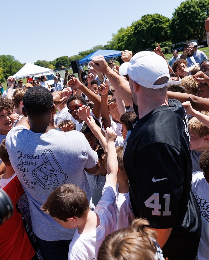 Collective Uplift Co-Founder Aaron Garland and NFL Player John Robert Spillane with children during the Spillane Youth Football Camp.  Photo provided by Collective Uplift.