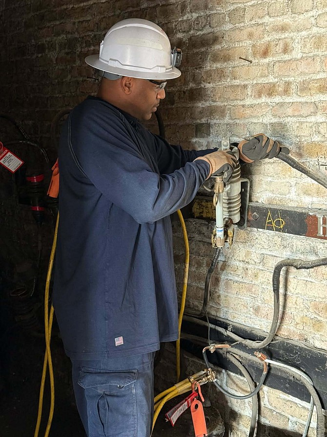 Mark Muhammad in a walk-in vault at the South Shore Cultural Center, safely replacing cable. Photo provided by ComEd.