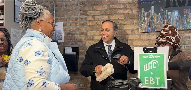 Raja assists Chicago residents buying groceries at Go Green Community Fresh Market in Englewood