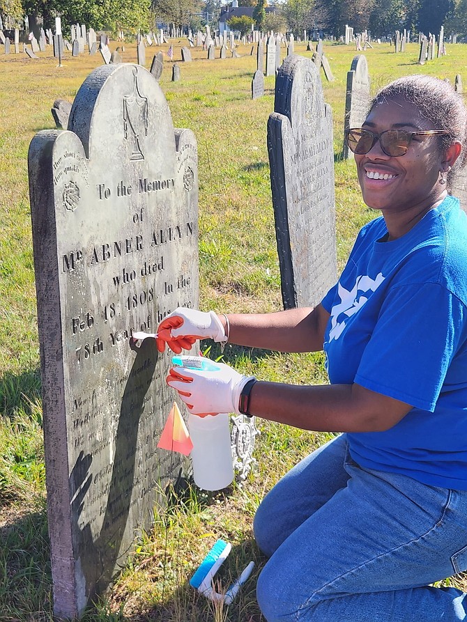 DAR Member and Rhode Island State Regent Dymond Bush cleans a historical headstone in honor of her two Revolutionary War Patriots of color. Daughters of the American Revolution.