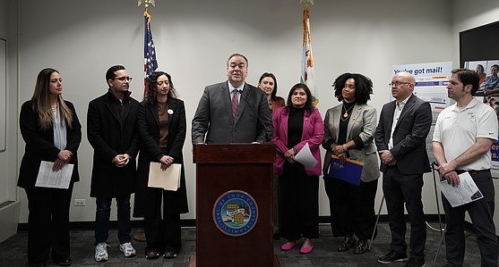 Cook County Assessor Fritz Kaegi (podium) stands with (l-r) Alderwoman Jeylú Gutiérrez, 14th Ward; Alderman Anthony Quezada, 35th Ward; Jessica Vásquez, Cook County Commissioner, 8th District; Kasia Kawa, Director of Customer Service, Cook County Assessor's Office; Jennifer Sanchez, Director of Communications, Cook County Assessor's Office; Tonika Johnson, Artist and Social Activist; Alderman Michael Rodriguez, 22nd Ward; Derek Giffin, Veterans Assistance Commission of Cook County.