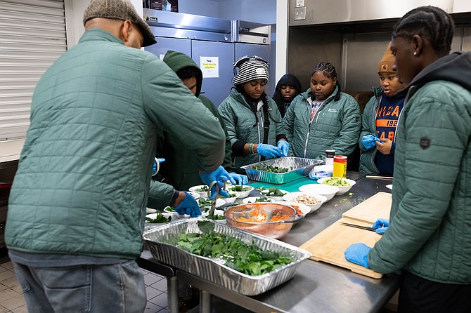 Bowen Harvest Farm's Entrepreneurship Instructor Joe Jones shows the students how to prepare salads. PHOTO COURTESY OF TASSI COMMUNICATIONS