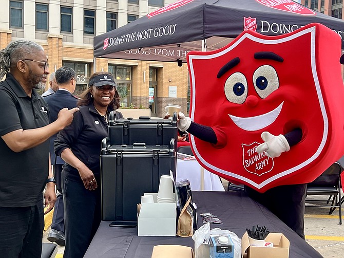 Momentum Coffee owner Nikki Bravo serves complimentary morning coffee to community members during The Salvation Army's National Donut Day celebration outside Jewel-Osco in Chicago on June 5, 2026. The Salvation Army mascot Shieldy joins in the fun.