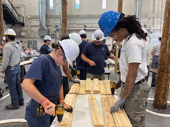 All hands-on deck for ComEd’s Bed Building initiative.  Participants nailed, measured and constructed materials needed to assemble the beds. The finished beds are being donated to needy children across Northern Illinois.  Photo courtesy of ComEd.