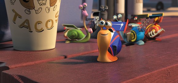 Turbo (foreground, Ryan Reynolds) enjoys the company of his new friends, the Racing Snails (from left): Smoove Move (Snoop Dogg), Whiplash (Samuel L. Jackson), Skidmark (Ben Schwartz) and Burn (Maya Rudolph).