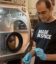 NASA plans to launch a 3-D printer to the International Space Station. Matthew Napoli, deputy program manager for the NASA 3-D printer program, examines a printed object.