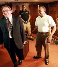 In this Saturday, Aug. 31, 2013, file photo, John Abarr, left, a kleagle of the United Klans of America, out of Great Falls, Mont., and Jimmy Simmons, center, president of the NAACP's Casper branch, arrive for a meeting Saturday night, Aug. 31, 2013, at the Parkway Plaza hotel in Casper, Wyo. Simmons spent several months attempting to organize the meeting due to concerns about reports of violence against black men and Ku Klux Klan pamphleting in Gillette, Wyo. The gathering, which took place in private under heavy security, was the first formal meeting between Klan and NAACP representatives that either side was aware of. (AP Photo/Casper Star-Tribune, Alan Rogers, File)