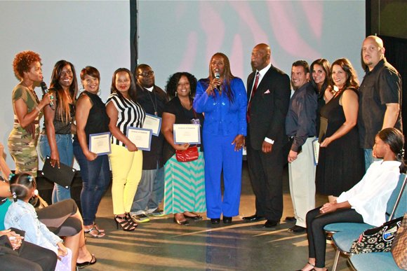 Participants in the Weight-A-Minute weight loss competition are honored by coach Mai Brooks, far left, and CEO Natalie Cole and COO David Miller, center.