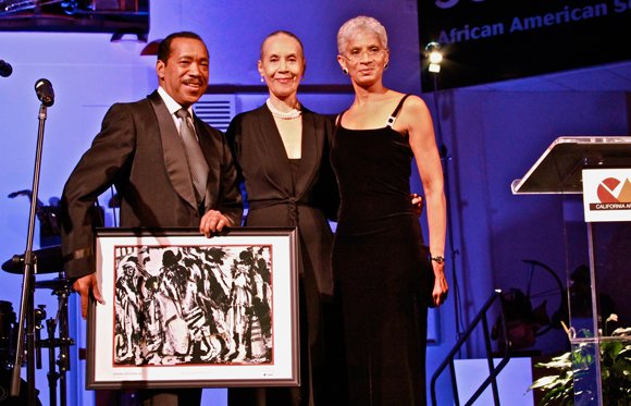 Emmy-award winning artist, Obba Babatundé (left) and Executive Director of the California African American Museum, Charmaine Jefferson (right), present legendary dance icon, Carmen De Lavallade and her husband, Geoffrey Holder (not pictured), with a Lifetime Achievement Award at CAAM’s annual gala.
