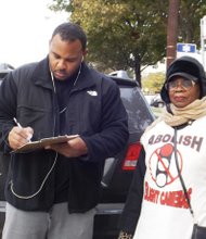 Tim Hughes stops to sign a petition during a protest held held at 53rd and Cottage Grove to abolish red-light enforcement and speed cameras that a group called Citizens to Abolish Red-light Cameras, led by Mark Wallace, of WVON, said are unfair and disproportionately located in African American communities.     