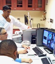 A new experimental procedure known as MRI-guided HIFU, uses magnetic-resonance imaging to focus heat-generating, high-intensity ultrasound onto fibroid tumor growths in women. Real-time MRI scans guide the ultrasound procedure and monitor temperatures in and around targeted tissues. Shown: Dr. Aytekin Oto and Nathaniel Crump of the University of Chicago monitor the MRI-guided HIFU procedure with the rest of the team.