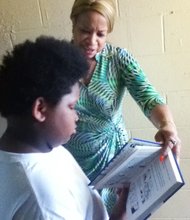 Walter Q. Gresham Elementary School principal Diedrus Brown reads a new library book with a student during the school's "Literacy Day" program.