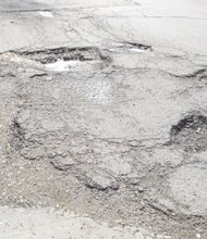 The potholes pictured here on the 2900 hundred block of Fulton Street on Chicago's west side are a hazard for drivers and pedestrians. Residents should call 311 to report the potholes and request repair or go to the City's website at cityofchicago.org.