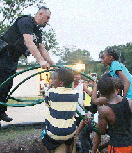 Officer Richard Chappell seesaws with children at Oak Grove Playground on South Side.