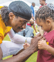 To this youngster's delight, Washington quarterback Robert Griffin III signs Destani Bailey's jersey Saturday during Fan Appreciation Dy at the teams's training camp in Richmond.  The team will hold its final practice at the facility Monday, Aug. 11.  Location:  2401 W. Leigh St.