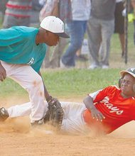 Darious Stanford covers for the Henrico Hitters as Kennedy Jones of the Hampton Grays slides safely into third base in a losing effort in the championship game of the Black World Series. The Hitters prevailed 14-4 to claim the title for 12 and under teams. Location: Parker Field Annex near The Diamond.