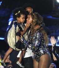  FILE - In this Sunday, Aug. 24, 2014 file photo, Beyonce on stage hugs Jay Z and their daughter Blue Ivy as she accepts the Video Vanguard Award at the MTV Video Music Awards at The Forum, in Inglewood, Calif. BET has suspended a producer after a joke about Blue Ivy’s hair aired Monday, Aug. 25, 2014, on the network’s music video countdown show, “106 & Park.” A source at the network, who spoke on the condition of anonymity because the person was not allowed to discuss the matter publicly, said the producer was suspended after the ill-fitting joke about Beyonce and Jay Z’s two-year-old daughter aired. (Photo by Chris Pizzello/Invision/AP, file)