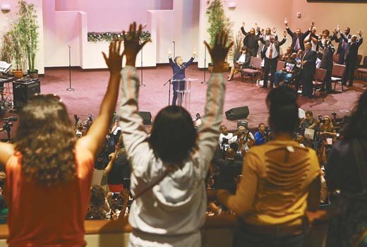 The Rev. Al Sharpton leads worship Sunday during a service for the Michael Brown family at the Greater Grace Church in Ferguson, Mo.