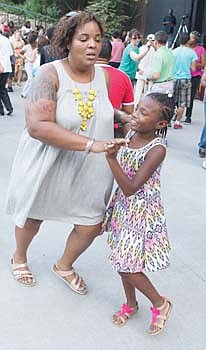 Denae Shepperson and her daughter, Raina, dance to the rhythmic beat at the Latin Jazz and Salsa Festival at Dogwood Dell in Byrd Park