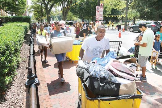 Stephen Guyton pushes his belongings toward his new home — a high-rise dorm at Virginia Commonwealth University. His mom, Valerie, and his sister, Taylor, follow with more items the Fredericksburg freshman brought with him. Location: Franklin Street near Monroe Park.  