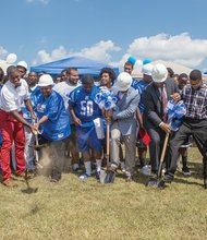 Schools and city officials and the John Marshall Justices dig in last Thursday for the ceremonial groundbreaking for the team’s new football field. The project will start with placement of turf and will be ready for play next season.