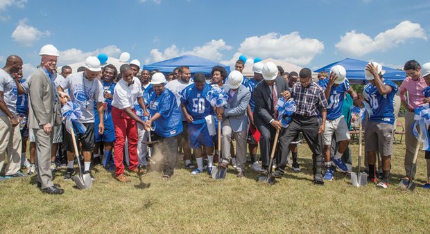 Schools and city officials and the John Marshall Justices dig in last Thursday for the ceremonial groundbreaking for the team’s new football field. The project will start with placement of turf and will be ready for play next season.