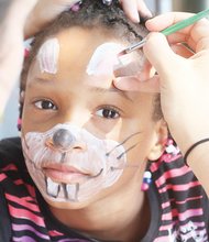 Eight year-old Aniyah Dudley gets her face painted at a back-to-school rally in the West End.