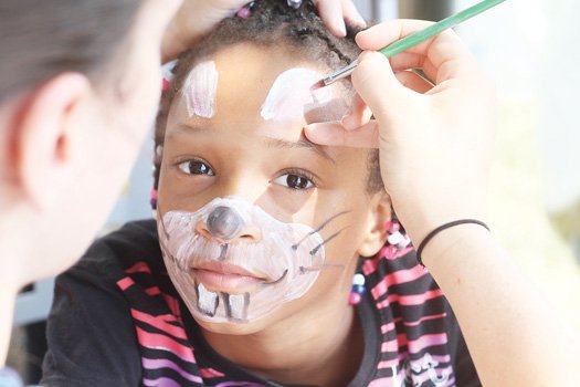 Eight year-old Aniyah Dudley gets her face painted at a back-to-school rally in the West End.