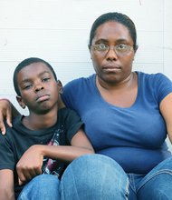 Javian Buffaloe sits with his mother, Tiffany, after returning home Tuesday from his first day of class at Martin Luther King Jr. Middle School.