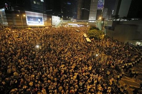 
Protesters gather at a main road in the financial central district after riot police use tear gas against them after thousands of people blocked the road in Hong Kong, Sunday, Sept. 28, 2014. Hong Kong police used tear gas on Sunday and warned of further measures as they tried to clear thousands of pro-democracy protesters gathered outside government headquarters in a challenge to Beijing over its decision to restrict democratic reforms for the city. (AP Photo/Vincent Yu)
