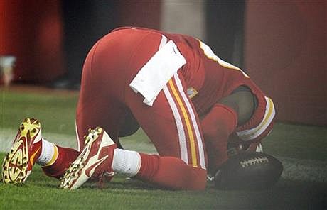 In this Sept. 29, 2014, photo, Kansas City Chiefs free safety Husain Abdullah prays after intercepting a pass and running it back for a touchdown during the fourth quarter of an NFL football game against the New England Patriots Monday, Sept. 29, 2014, in Kansas City, Mo. The NFL said Tuesday, Sept. 30, that Abdullah should not have been penalized for unsportsmanlike conduct when he dropped to his knees in prayer after the interception. (AP Photo/Ed Zurga)
