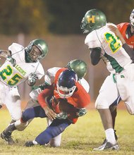 Huguenot defenders corral a George Wythe ball carrier in Friday night’s game at Armstrong High School.