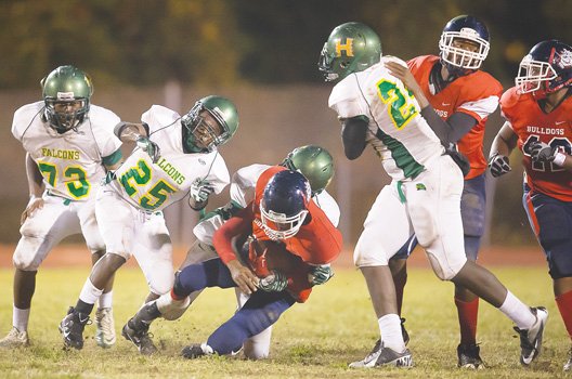 Huguenot defenders corral a George Wythe ball carrier in Friday night’s game at Armstrong High School.