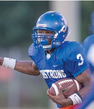 Armstrong quarterback De’Shaun Waller eyes an opening in the game against Varina.