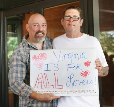 Sam Howerton, left, and Ryan Gardner, displaying their message of love, were the first male same-sex couple to buy a marriage license in Richmond.