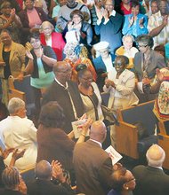 Audience members stand in ovation Saturday honoring Richmond music icon Harold S. Lilly Sr. at an event commemorating his life and musical career as an organist. His daughter, Allison, escorts him through the appreciative crowd in the tribute titled, “The Heart of a Servant.”