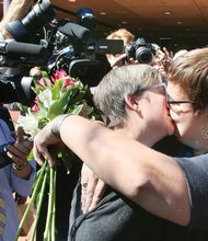 Nicole Pries, left, and Lindsey Oliver kiss after an impromptu ceremony outside the Downtown courthouse Monday. They became the first same-sex couple to wed in Richmond.