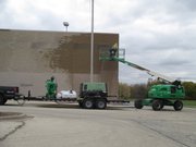 A worker cleans the exterior masonry of the former Cub Foods store, which is being converted into a new church for the Harvest Bible Chapel Joliet.