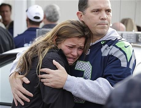 People react as they wait at a church, Friday, Oct. 24, 2014, where students were taken to be reunited with parents following a shooting at Marysville Pilchuck High School in Marysville, Wash. (AP Photo/Ted S. Warren)
