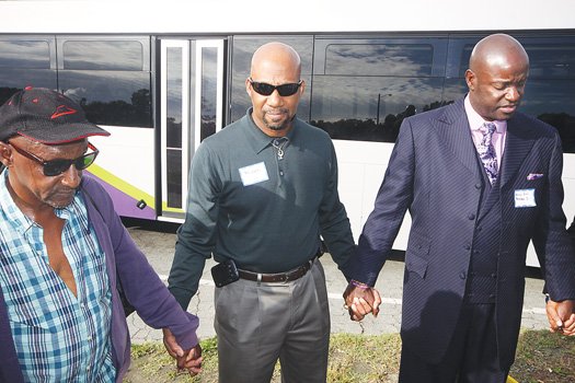 An estimated 150 clergy members boarded chartered GRTC buses and traveled down metro Richmond’s four major transportation corridors, where they prayed at stops and listened to the concerns of public transit riders last Thursday about the need for a comprehensive regional rapid transit system. Above, from left, Ishaq Shabazz, the Rev. Micah McCreary and Bishop Daniel Robertson Jr. pray at the end of the Hull Street Road bus line in South Side. The event was held in conjunction with the 5th Annual Metro Richmond Clergy Convocation. Riders boarded outside Richmond Hill ecumenical center in Church Hill, which organized the event with the Samuel DeWitt Proctor School of Theology at Virginia Union University.
