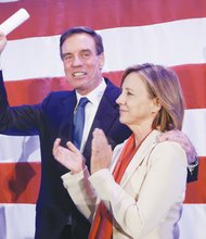 U.S. Sen. Mark Warner waves to the crowd with his wife, Lisa Collis, at an election party in Arlington.