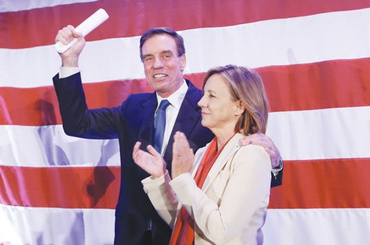 U.S. Sen. Mark Warner waves to the crowd with his wife, Lisa Collis, at an election party in Arlington.
